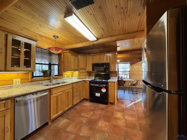 kitchen featuring a wealth of natural light, hanging light fixtures, black appliances, and sink