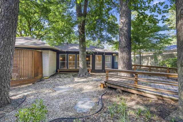 616 Cynthia St, Longview, TX 75605 - rear view of property with a deck, brick siding, roof with shingles, and fence