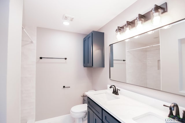 bathroom featuring double vanity, toilet, a shower, and a sink