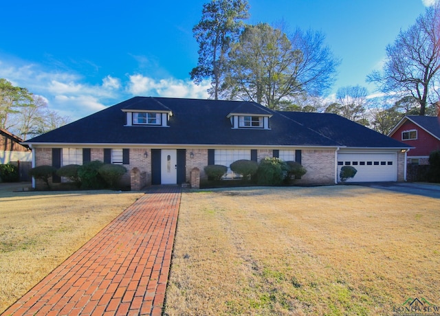 view of front of property featuring brick siding, an attached garage, driveway, and a front lawn