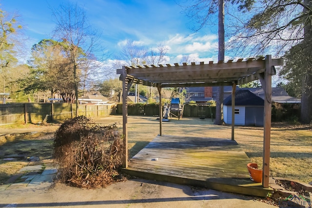 wooden terrace featuring a shed, an outdoor structure, and a fenced backyard