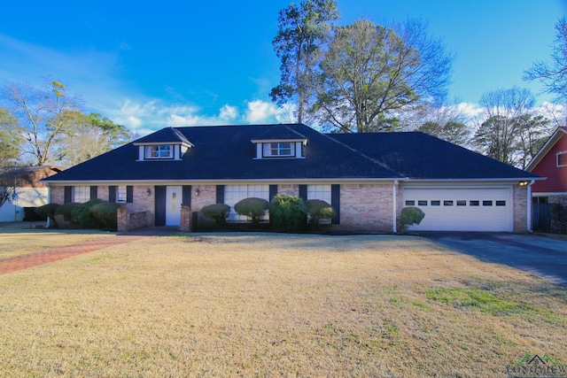 view of front facade with a front lawn, a garage, brick siding, and driveway