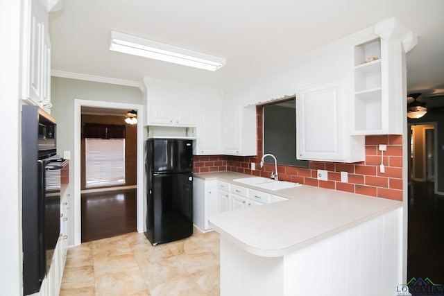 kitchen with ceiling fan, a peninsula, freestanding refrigerator, and a sink