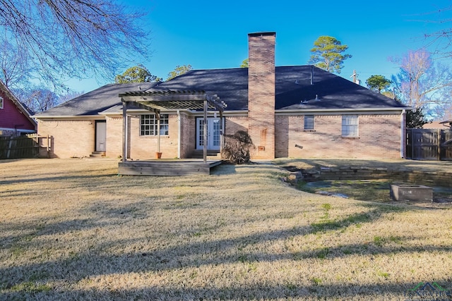 rear view of property with a pergola, a yard, and fence