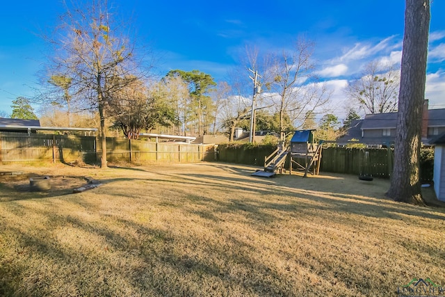 view of yard featuring a playground and a fenced backyard