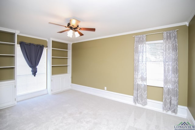 carpeted spare room featuring a ceiling fan, baseboards, and ornamental molding