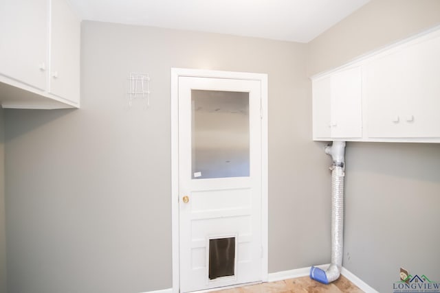 laundry area featuring cabinet space and baseboards