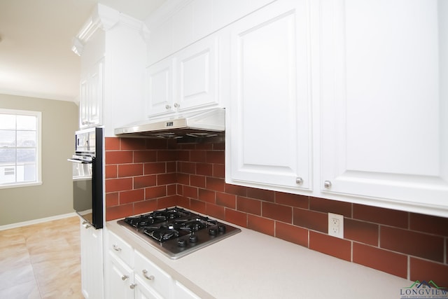 kitchen with backsplash, oven, under cabinet range hood, stainless steel gas cooktop, and white cabinets