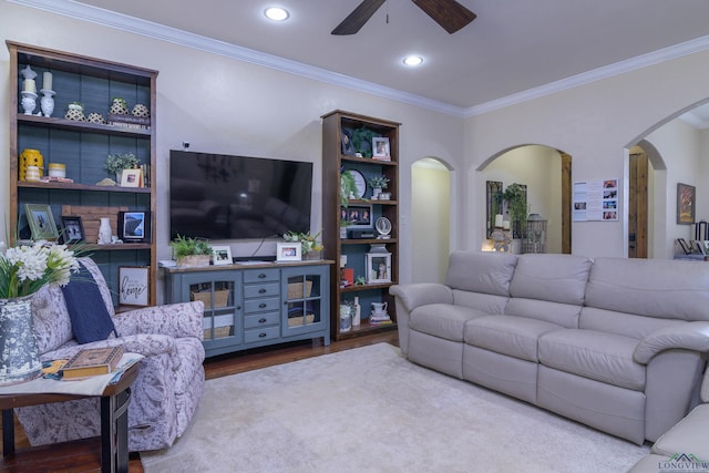 living room with hardwood / wood-style flooring, ceiling fan, and ornamental molding