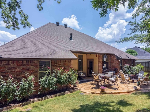 rear view of property with a patio area, a yard, and an outdoor fire pit