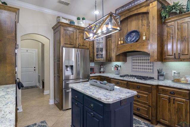 kitchen featuring light stone countertops, hanging light fixtures, tasteful backsplash, a kitchen island, and appliances with stainless steel finishes