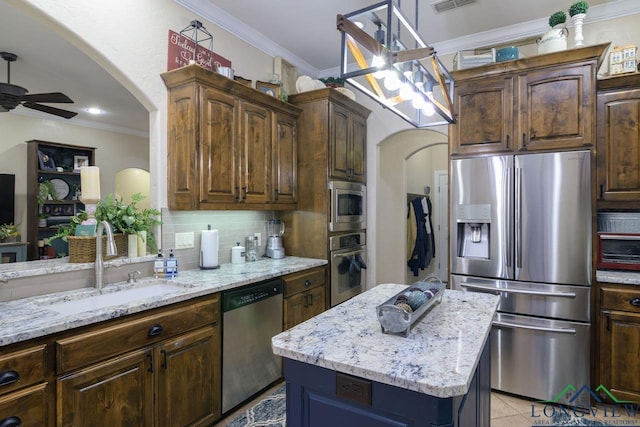 kitchen featuring a center island, stainless steel appliances, ornamental molding, and sink