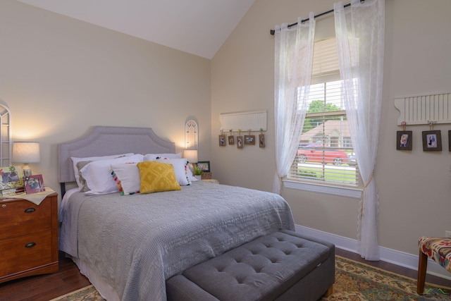 bedroom with multiple windows, dark wood-type flooring, and vaulted ceiling