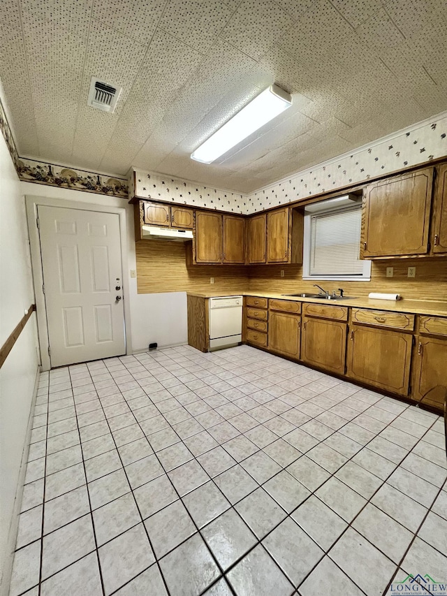 kitchen featuring dishwasher, light tile patterned floors, and sink