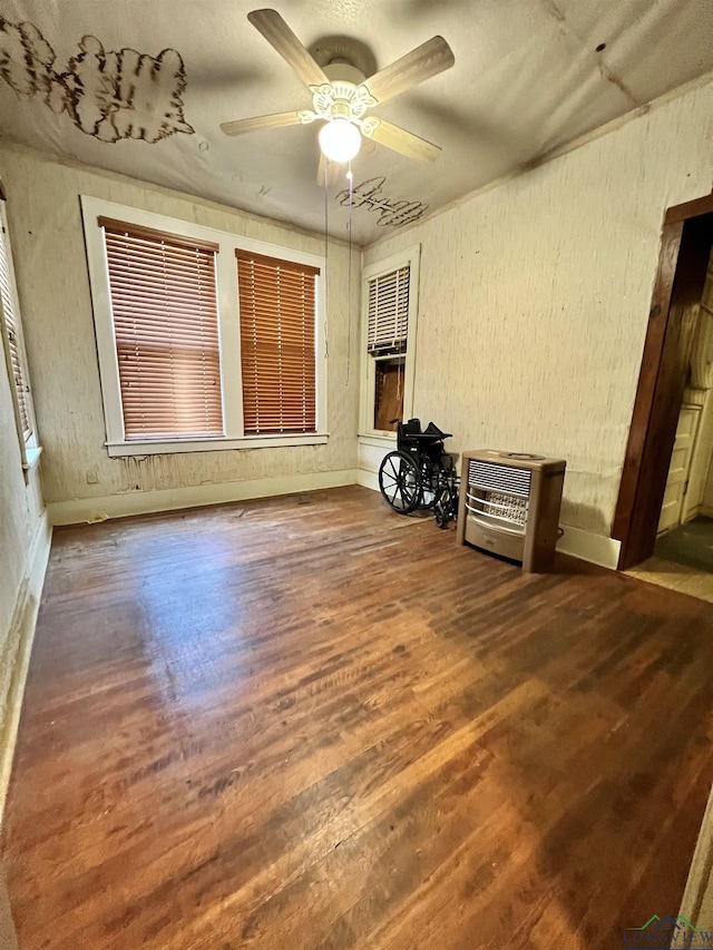 interior space with hardwood / wood-style flooring, ceiling fan, and heating unit