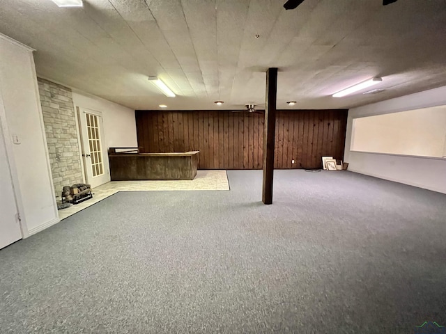 basement with wooden walls and light colored carpet