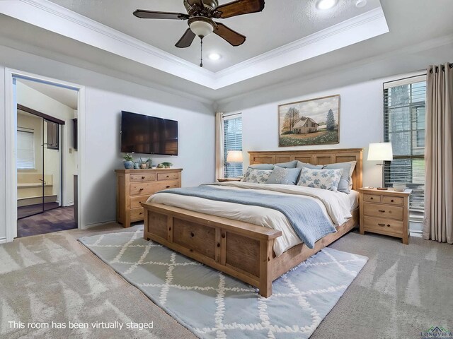 bedroom with crown molding, carpet flooring, and a tray ceiling