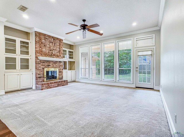 unfurnished living room with visible vents, a ceiling fan, ornamental molding, baseboards, and carpet flooring