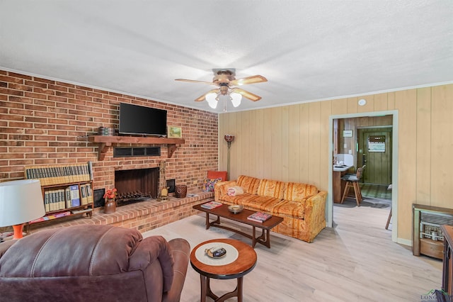 350 Capri St, Ore City, TX 75683 - living area with ceiling fan, light wood-style floors, a fireplace, wood walls, and heating unit