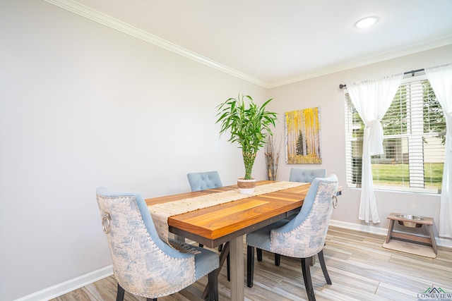 dining space with crown molding and light hardwood / wood-style floors