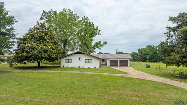 ranch-style home featuring a garage and a front lawn