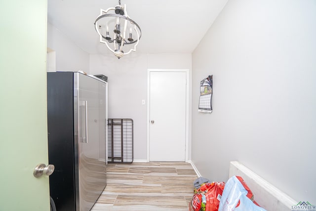 corridor featuring light hardwood / wood-style floors and a chandelier