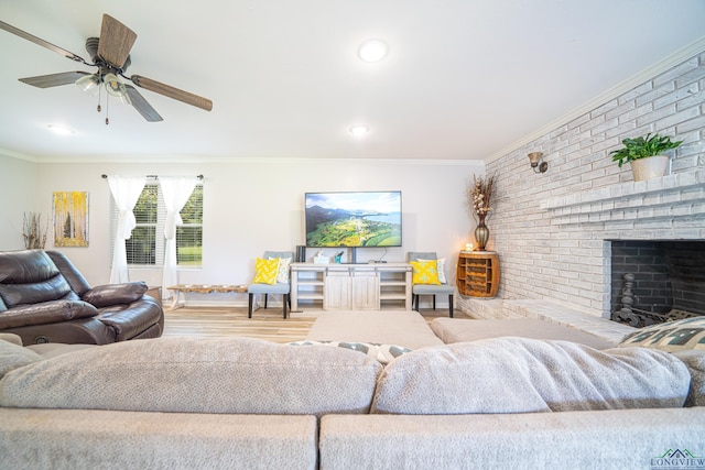 living room featuring ceiling fan, light hardwood / wood-style floors, crown molding, and a fireplace