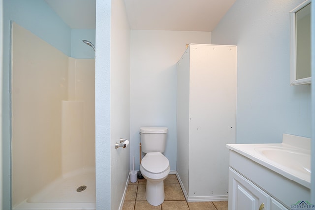 bathroom with tile patterned flooring, vanity, toilet, and walk in shower