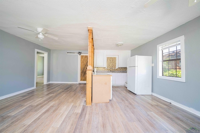 115 Yates St, Mount Vernon, TX 75457 - kitchen featuring freestanding refrigerator, a ceiling fan, white cabinets, light wood finished floors, and light countertops
