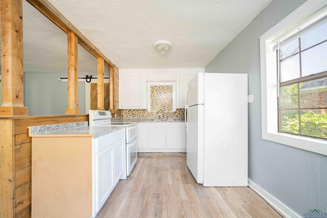 115 Yates St, Mount Vernon, TX 75457 - kitchen featuring white appliances, white cabinets, light wood-style flooring, decorative backsplash, and light countertops
