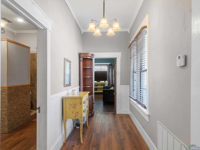 hall with wainscoting, visible vents, ornamental molding, and wood finished floors