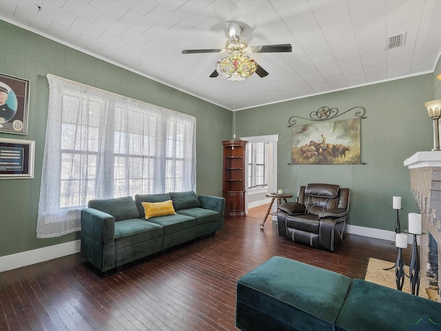 living room with a brick fireplace, visible vents, and wood-type flooring