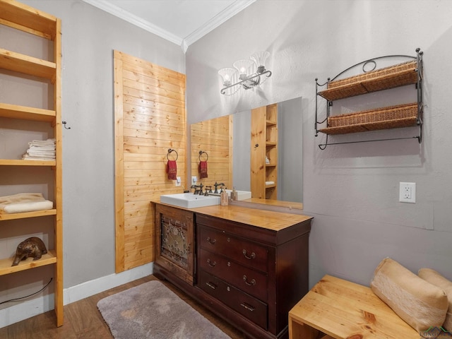 bathroom featuring crown molding, baseboards, a chandelier, wood finished floors, and vanity