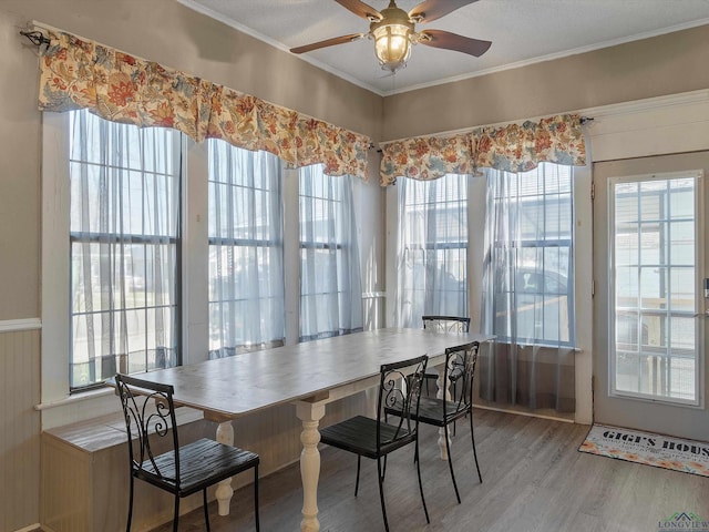 dining area featuring crown molding, wood finished floors, and ceiling fan