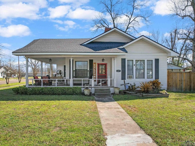 bungalow with a front yard, fence, covered porch, and a chimney