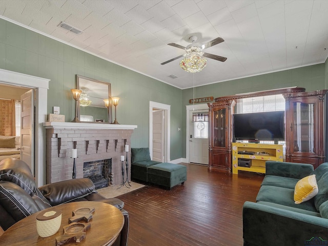 living room featuring visible vents, a brick fireplace, ornamental molding, wood finished floors, and a ceiling fan