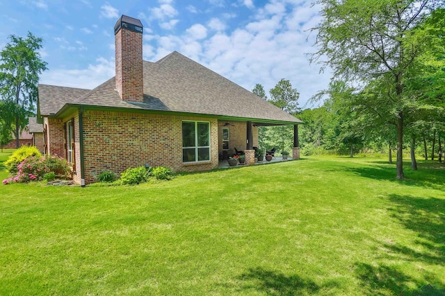 rear view of house featuring a yard