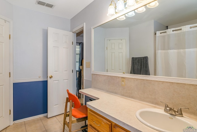 bathroom featuring tile patterned flooring, vanity, and walk in shower