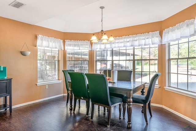 dining area featuring a healthy amount of sunlight, dark hardwood / wood-style floors, and a notable chandelier