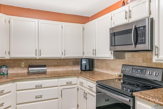 kitchen featuring tasteful backsplash, white cabinetry, black electric range oven, and stone countertops