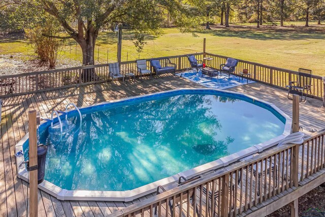 view of pool featuring a deck and a yard