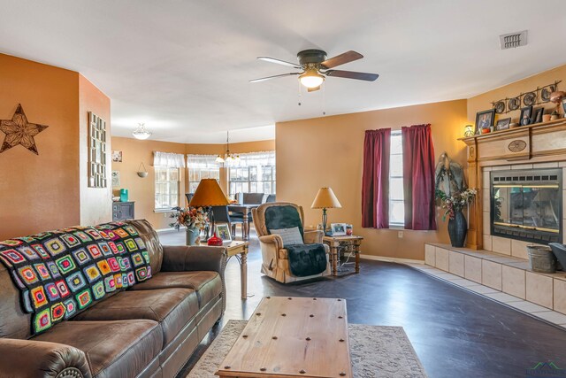 living room with ceiling fan, a healthy amount of sunlight, and a tiled fireplace