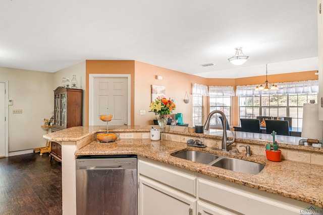 kitchen featuring dishwasher, a chandelier, light stone countertops, and sink