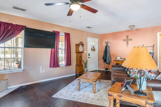 living room with ceiling fan and dark wood-type flooring