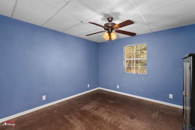 spare room featuring a paneled ceiling and concrete floors