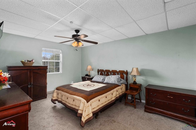 carpeted bedroom with ceiling fan and a drop ceiling