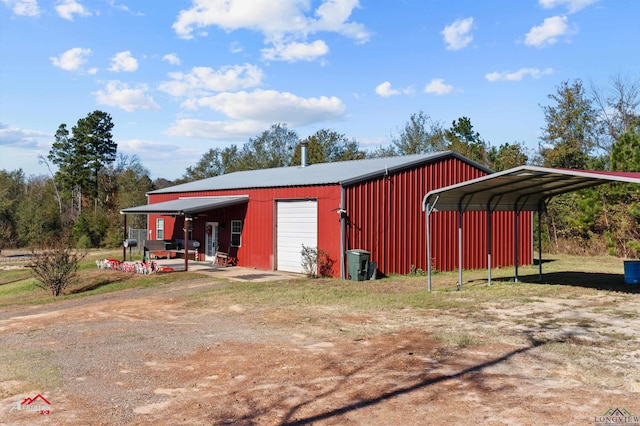 view of outdoor structure with a carport and a garage