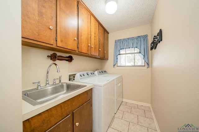 1002 Ruby St, Gilmer, TX 75644 - laundry area featuring a sink, a textured ceiling, baseboards, independent washer and dryer, and cabinet space