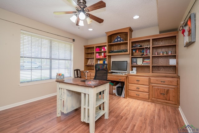 1002 Ruby St, Gilmer, TX 75644 - home office with baseboards, a ceiling fan, a textured ceiling, and light wood-type flooring