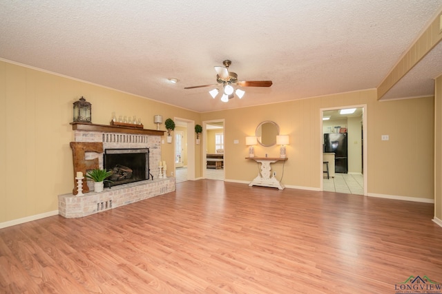 1002 Ruby St, Gilmer, TX 75644 - unfurnished living room featuring ceiling fan, ornamental molding, wood finished floors, and a textured ceiling